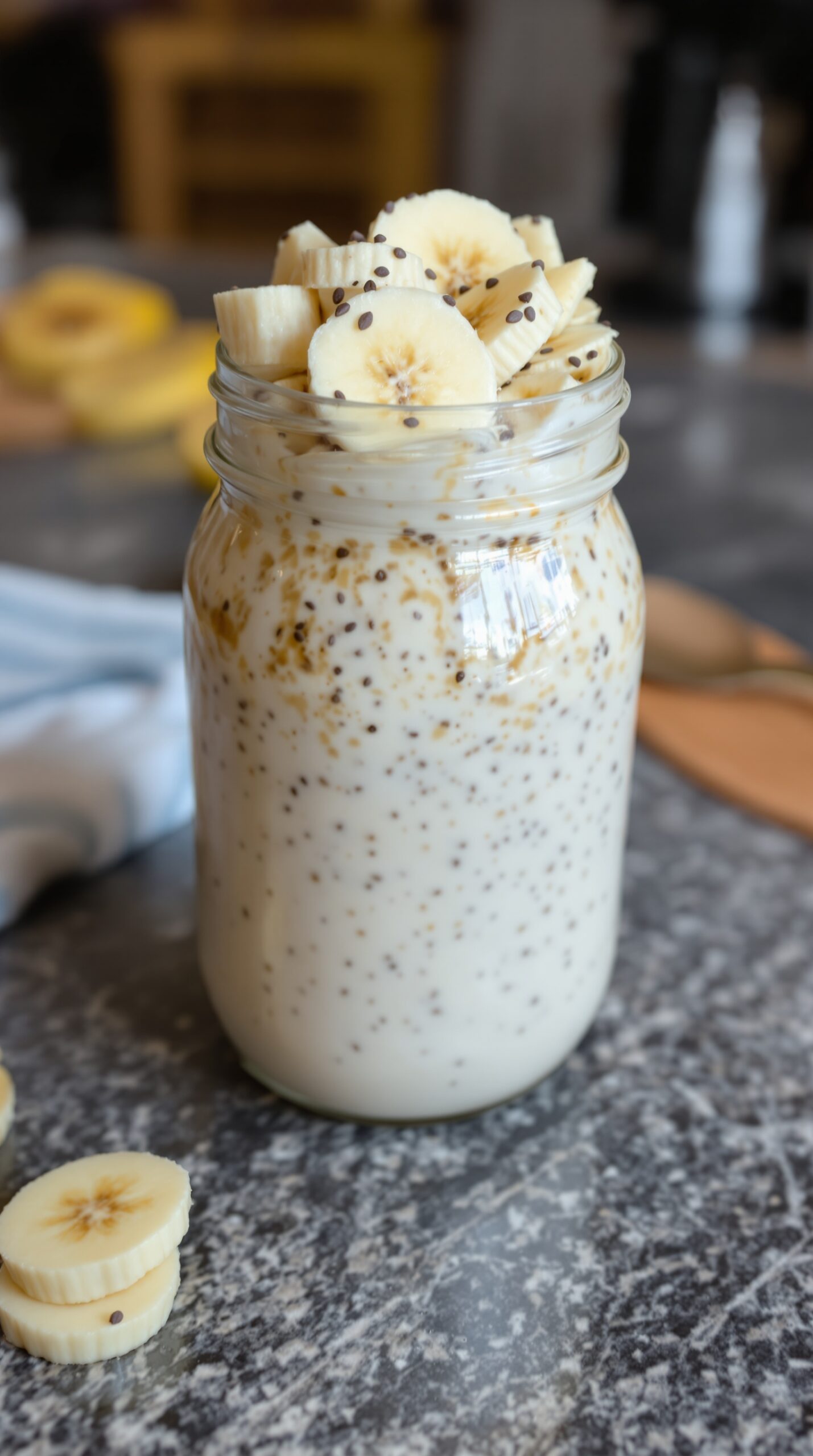 A jar of overnight oats with almond milk topped with banana slices.
