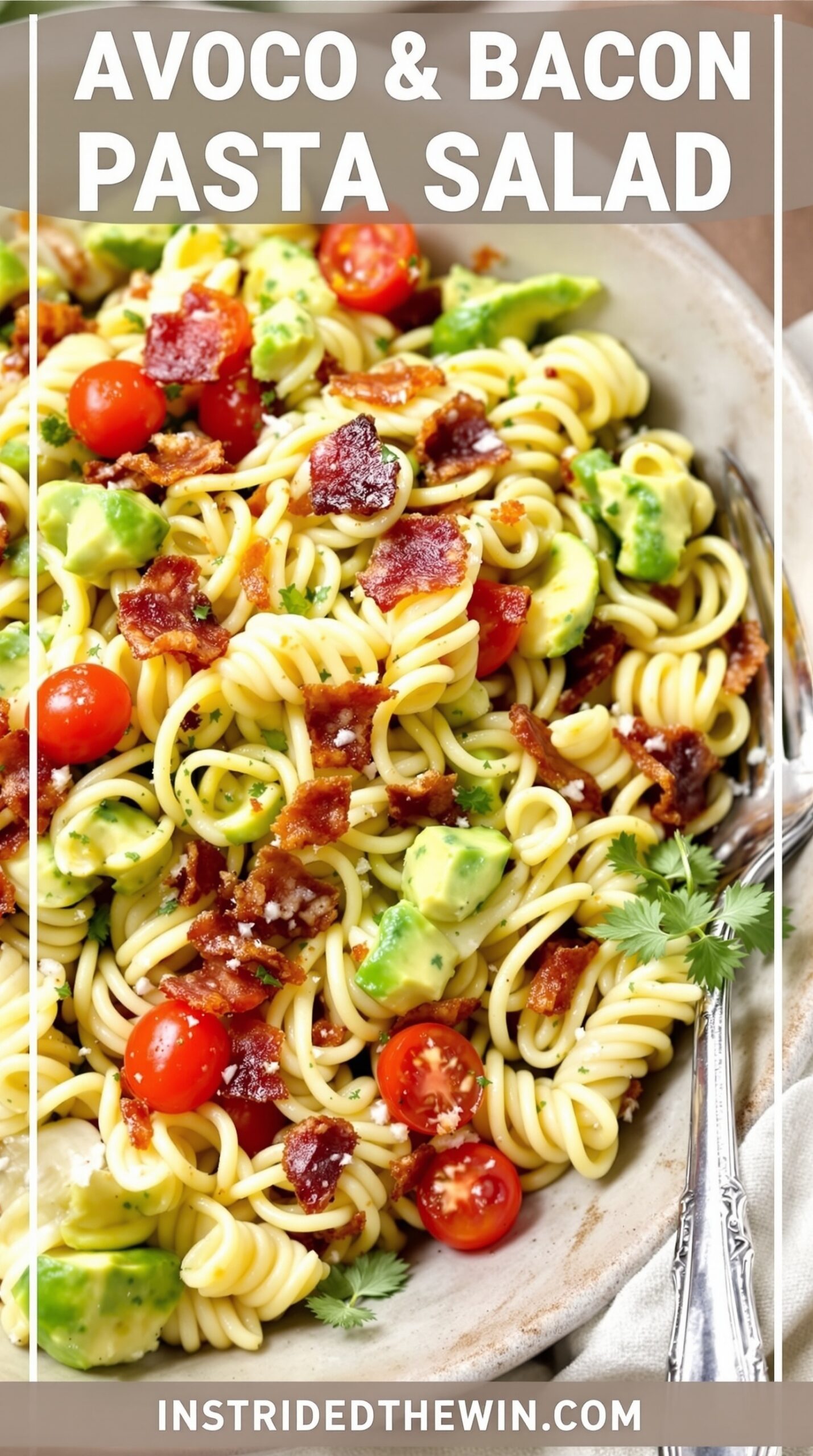 A bowl of avocado and bacon pasta salad with cherry tomatoes and cilantro.